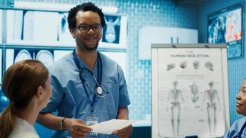 Expert assistant discussing hospital records with specialists team in a meeting, medical staff evaluating a new treatment plan. Medics at a private clinic analyzing exam test results. Camera A. photo