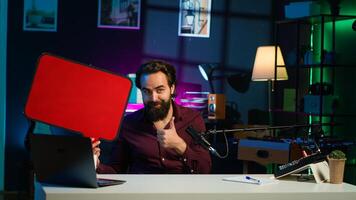 Man arriving in studio, filming sponsored content, holding empty copy space sign, following script, talking to audience. Internet star using cardboard bubble speech cutout to do marketing, camera A photo