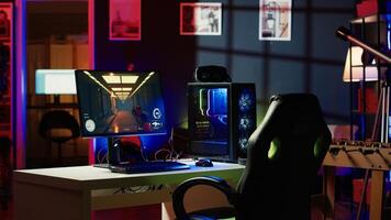 Stylish empty apartment with artwork on walls and computer screen left open at night showing videogame interface. Home living room with no people in and monitor left open photo