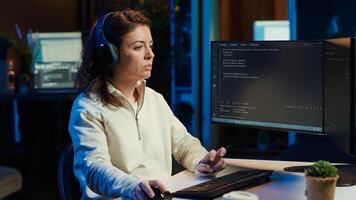 IT programmer listening music while fixing vulnerabilities in software compromising operating system. Cybersecurity expert wearing headphones and using PC to patch security exposures, camera A photo