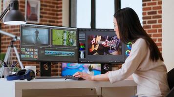 Freelancer asian woman creator works on a movie project, multitasking with dual monitors, editing software and a color wheel in her home workspace. Film editing industry. Camera B. photo