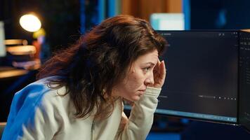 Cybersecurity specialist looking confused at computer screen while trying to fix broken code. Contemplative developer feeling worried and anxious about programming errors, camera A photo