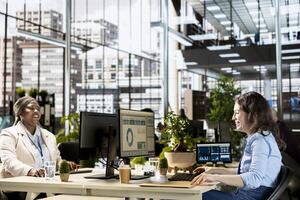 Young office employee overseeing business operations at workstation, working with numbers and data for administrative tasks in a multinational company. Strategic planning management. photo