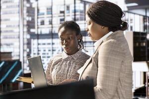 African american CEO and employee review company numbers, creating a roadmap that includes goals, strategies and resource allocation management. Specialists meet corporate objectives. photo