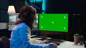 Freelancer works on isolated screen desktop computer on digital portfolio showcasing edited videos. editor selecting best clips using retouching application on chroma key display, camera B photo