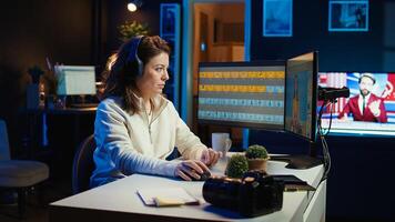 Freelancer editing professional photographs, working in home studio while enjoying music. Photo editor using headphones to listen favorite songs while using editing software, camera B