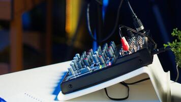 Close up shot of specialized radio equipment used in home studio by dj to produce music and record internet show. Empty living room with rgb lights and entertainment gadgets photo
