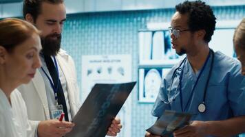 Physicians and radiologists analyzing x ray scans to create an effective treatment plan. Medics doing teamwork at a private clinic to ensure radiography based diagnostics for healthcare. Camera A. photo