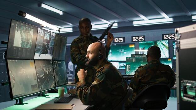 Army telecommunication systems operator using radio and satellite equipment. Middle Eastern military dispatcher managing communications networks, looking at screens, camera B photo