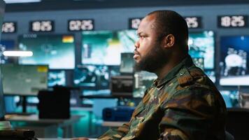 Soldiers working in governmental facility, doing surveillance with digital radar equipment, operating missile systems. Man monitoring army HQ CCTV for any unauthorized activity, camera A photo