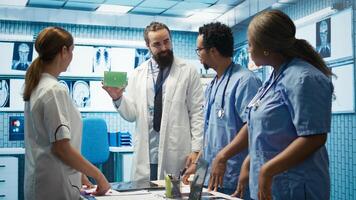 Medical expert showing a box with green screen during a meeting for diagnosis and disease prevention, conducting a detailed evaluation of x ray scans and lab test results in a clinic. Camera B. photo
