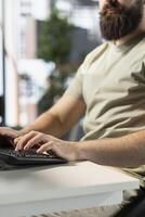 Data scientist typing on keyboard, doing software quality assurance, writing source code on computer. Close up of man in office inspecting coding on PC device, looking to fix potential issues photo