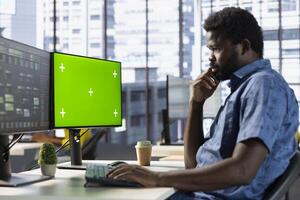 Programmer conducting tests on isolated screen computer to optimize machine learning models for performance and accuracy. IT specialist in office analyzing complex AI data on chroma key PC photo