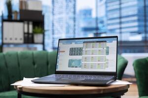 Modern work environment in a stylish skyscraper downtown building, high end workspace with business infographics trends running on laptop. Career development and growth, office life. photo