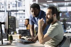 Data engineer and coworker at PC desk developing machine learning algorithms. Programmer and colleague in office solving tasks, training large scale deep learning models using computer photo