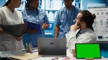 Diverse team of medics analyze x rays next to mockup copy space and discuss treatment plans in a medical office. Healthcare specialists working to provide diagnosis on insurance. Camera B. photo