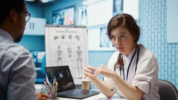 Physician meets with a patient to discuss medical results in a cabinet, using advanced diagnostic equipment to interpret x ray scans, demonstrating a professional healthcare approach. Camera B. photo