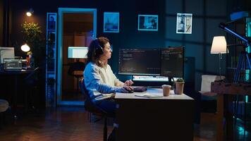 IT programmer listening music while fixing vulnerabilities in software compromising operating system. Cybersecurity expert wearing headphones and using PC to patch security exposures, camera B photo