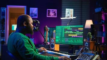 Music composer plays electronic keyboard piano keys and recording new tracks, creating audio recordings before launching music. Artist producer uses synthesizer, post production. Camera B. photo