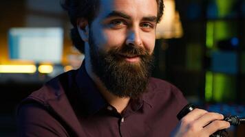 Portrait of smiling influencer in home studio doing live broadcast for online streaming platforms, talking with fans. Jolly media star telling viewers facts about himself, camera A close up photo