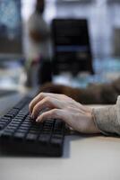 Developer typing on keyboard in server farm, ensuring compliance with industry standards and regulatory requirements. Close up of data center IT specialist conducting security audits photo