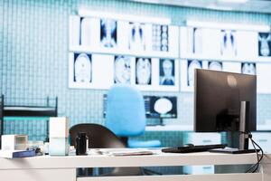 Professional healthcare office with diagnostic tools and a pc display, showcasing a designated check up space for healthcare examinations. Medical consultations in an empty clinic space. photo