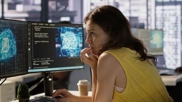 Woman in office using laptop to steal company secrets after being hired by competitor, hiding from manager. Sneaky employee closing notebook lid to hide while ilegally downloading data, camera A photo
