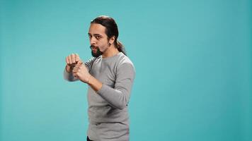 Man pretending to fight, throwing punches, holding defensive guard. Martial artist person doing mock boxing, holding combat stance, exercising, isolated over studio background, camera B photo