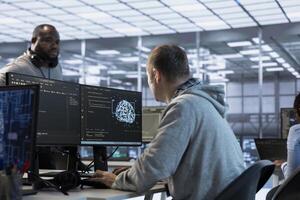 Software developers using machine learning applications to optimize server farm operations. Team of IT specialists using PC to implement server virtualization in data center facility photo