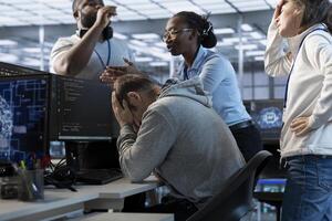 Employees berating engineer in office after mistake leading to errors in high tech AI data center. IT workers scolding admin in server farm after damaging artificial intelligence supercomputers photo