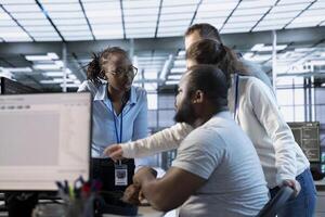 System admins doing brainstorming in computer network security data center workplace, ensuring optimal performance. Coworkers monitoring energy consumption across server racks, working together photo