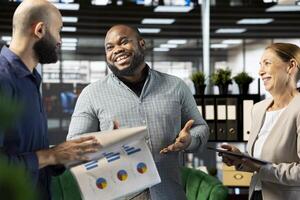 Happy manager satisfied with progress done on customer commissioned project after reading company documents. Cheerful supervisor pleased with key data statistics on paperwork after business audit photo