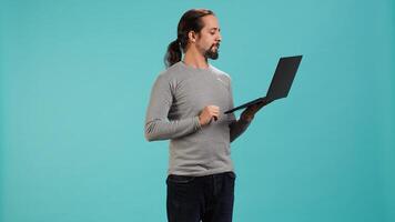 Man using laptop to do business related tasks for company, isolated over studio background. Office clerk doing budgeting, forecasting, and financial analysis on notebook, camera A photo