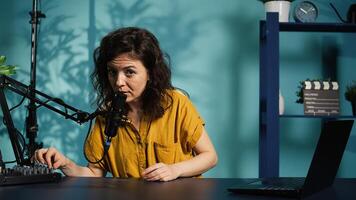 Content creator preparing podcast recording equipment, waiting for guests to arrive and film . Online show host testing professional microphone before conducting interviews in studio, camera B photo