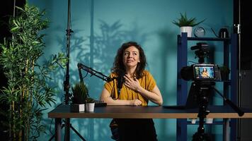 Professional camera used for recording woman chatting with online audience, filming in home studio. Media star discussing with fans during live broadcast stream recorded with advanced gear, camera B photo
