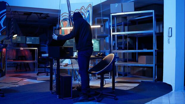 Hacker leaving secret base with SSD in briefcase containing data obtained from victim after tricking it into installing ransomware program. Man exiting base of operations with suitcase, camera A photo