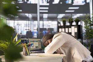 Office clerk falling asleep at computer desk while looking through financial business documents over accounting figures. Exhausted employee working late, suffering sleep deprivation, taking nap photo
