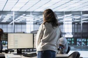 Engineer standing in computer network security data center, working to ensure optimal performance. Worker monitoring energy consumption across operational server racks components photo