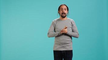 Disappointed man admonishing friend over debacle, isolated over blue studio background. Upset person in disagreement with mate, pointing finger and lecturing him, camera A photo