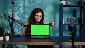 Internet show host being sponsored by partnering brand to do green screen laptop unboxing content. Tech specialist does influencer marketing, doing mockup notebook product placement, camera B photo