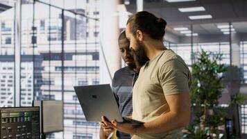 Programmer and colleague conducting experiments and tests to optimize machine learning models for performance and accuracy. IT staff members in office analyzing and interpreting complex data, camera A photo