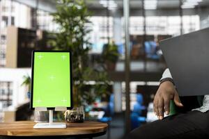Isolated screen tablet used by bookkeeper preparing paperwork for business meeting. Mockup device next to office clerk using notebook in startup to do research analysis, reading email files, close up photo
