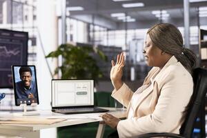 Interviewer holding teleconference meeting with job candidate, greeting him and asking questions before hiring him. HR employee saluting man, interviewing him for open position photo