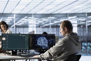 Computer scientist in data center coding AI LLM chatbo answering user prompts using predictive technology. Server room employee building large language model program using artificial intelligence photo