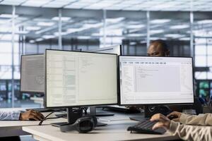 Lines of code running on computer screens in data center, used by employees to troubleshoot rackmounts in server rows. IT scripts ran by workers on PC monitors, upgrading hardware photo