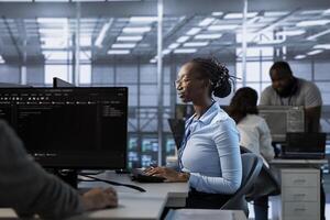 Programmer in server farm implementing power management solutions to reduce energy consumption. African american employee integrating new technologies and systems in data center photo