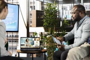 Supervisor greeting collaborators working from home, holding videoconference meeting to present new client commissioned project. Management executive talking with employees in online videocall photo