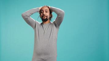 Disappointed man admonishing friend over debacle, isolated over blue studio background. Upset person in disagreement with mate, pointing finger and lecturing him, camera B photo