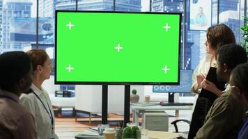 Diverse group of startup employees looking at green screen on an interactive board, meeting to discuss ideas and details to ensure organizational progress. Forecast affiliates in office. Camera A. photo