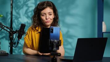 Tech expert presenting tablet in entry level low budget price range, filming from dimly lit home studio. Viral tech content creator reviewing digital device in front of online audience, camera A photo